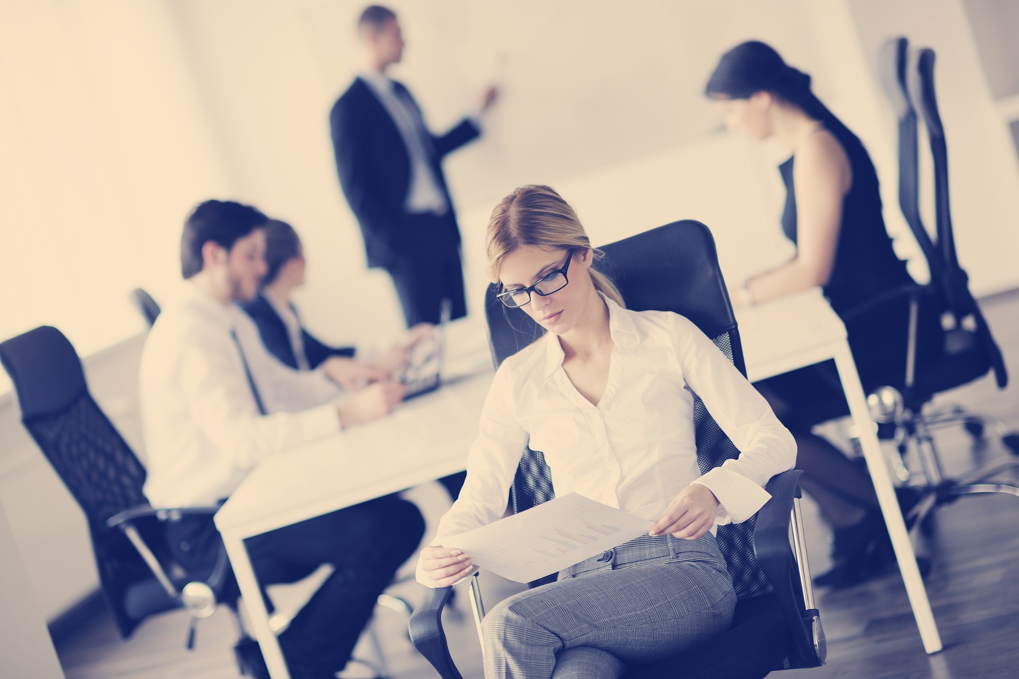 business woman with her staff in background