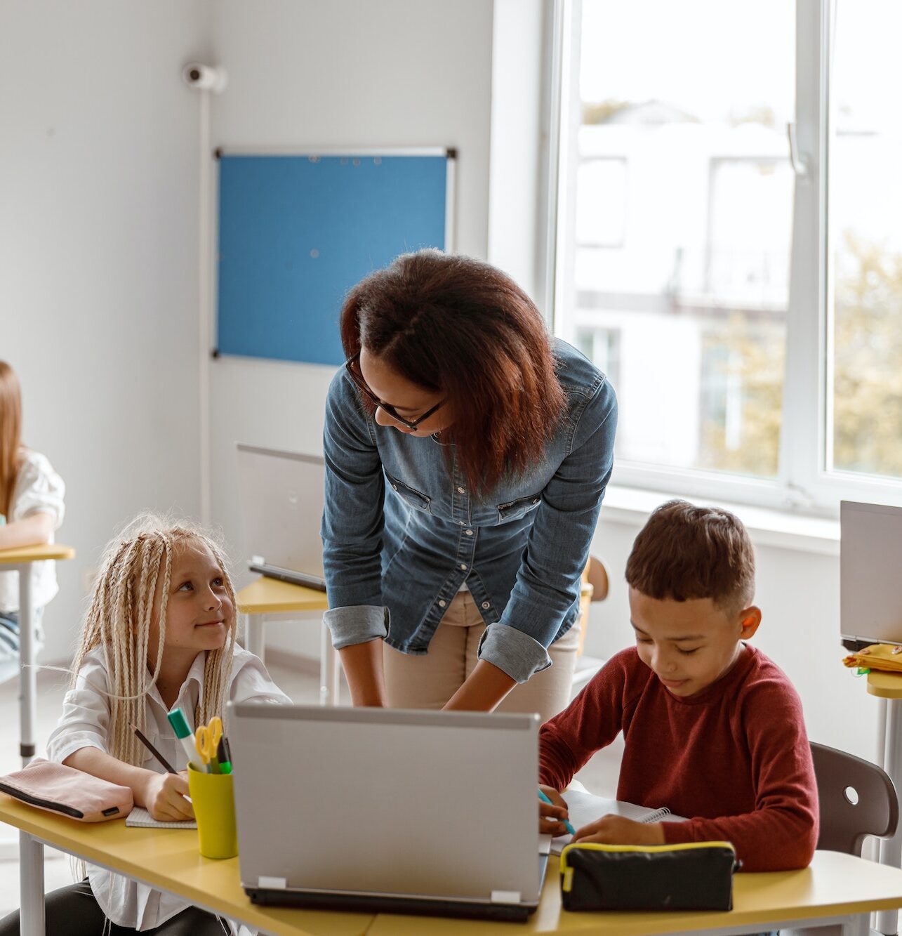 Female teacher explaining the task to schoolchildren